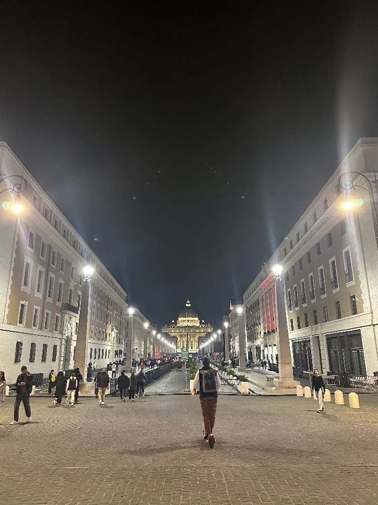 Boy on a scooter looks to Saint Peter's